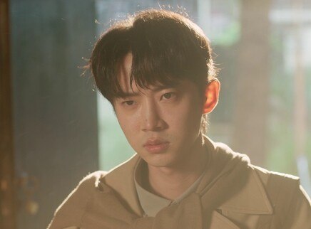 《龙行龘龘》第1集官方封面剧照，身穿风衣的青年坐在窗边